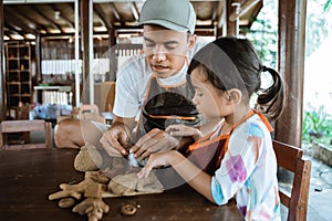 Asian father and daughter working with clay