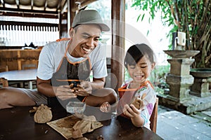 Asian father and daughter working with clay