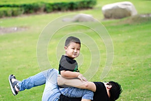 Asian father and son having fun in park photo