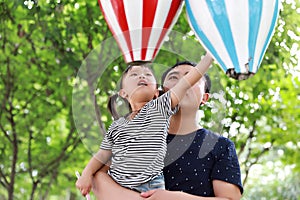 Asian Father embrace hug daughter dad love girl child play have fun in a park outdoor summer day family activity happy childhood