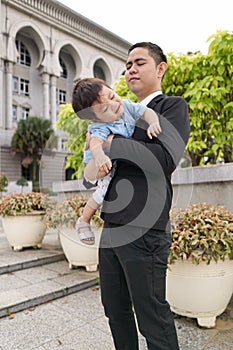 Asian father and his adorable son together wearing smart attire spending quality time together.