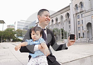 Asian father and his adorable son together wearing smart attire spending quality time together.