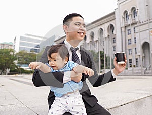 Asian father and his adorable son together wearing smart attire spending quality time together.