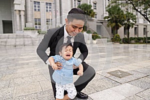 Asian father and his adorable son together wearing smart attire spending quality time together.