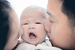 Asian father mother and baby son plays at home.