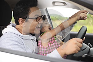 Asian Father Playing with His Daughter in Car