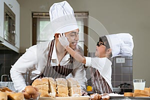 Asian father and son are happy and having fun in the kitchen making bakery