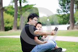 Asian father and son having fun in park