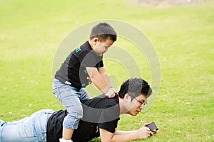 Asian father and son having fun in park