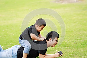 Asian father and son having fun in park