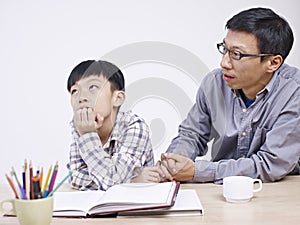 Asian father and son having a serious conversation