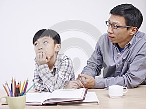 Asian father and son having a serious conversation photo