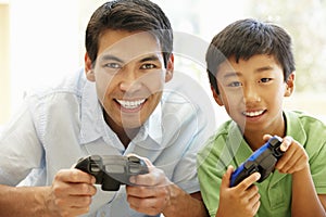 Asian father and son playing videogames photo