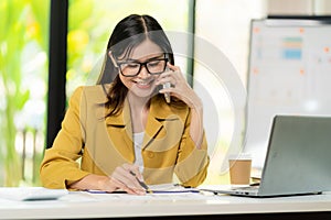 Asian female accountant talking on the phone She is a salesperson at a startup company.