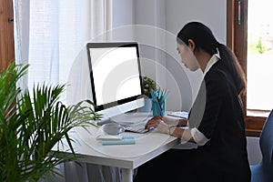Asian female accountant working with computer at office.