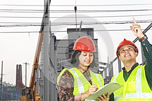 Asian female architect and male foreman having a discussion on location site