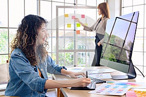 Asian female artist drawing something on graphic tablet. graphic designer working at office