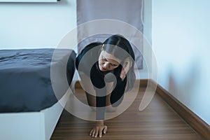 Asian female bent and searching something under bed lost thing in bedroom