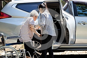 Asiatico una donna aiutiamo non valido più vecchio una donna sedia a rotelle sul Ottenere auto utile cura un supporto 