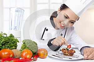 Asian female chef garnishing photo