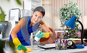 Asian female cleaning desk in office