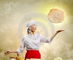 Asian female cook making pizza