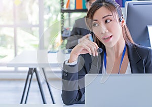 Female customer service is answering call on headphone in an operator service office