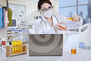 Asian female doctor analyse liquid at clinic