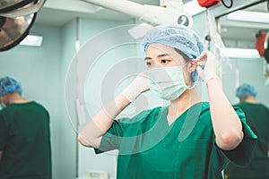 Asian female doctor, attractive and young wearing a mask to prepare for work in the operating room