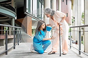 Asian female doctor examining the knee injury of an elderly female patient