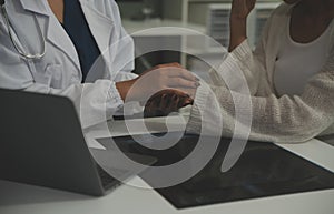 Asian female doctor giving hope and encourage to stressed woman patient at hospital. Smiling doctor woman touching on patient