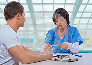 Asian female doctor holding and lookin medical thermometer photo