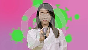 Asian female doctor holding stethoscope with coronavirus cells background