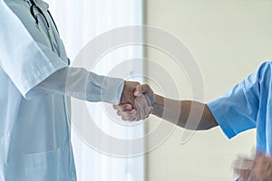 Asian female doctor at the hospital or clinic giving an handshake to hre patient photo
