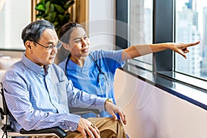 Asian female doctor or nurse treats elderly patient suffering from depression he was sitting in a wheelchair. The concept of