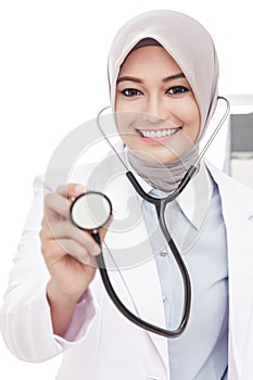 Asian female doctor smiling while using stethoscope