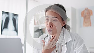 Asian female doctor using laptop computer online video call remote talking to patient, prescribe medicine