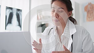 Asian female doctor using laptop computer online video call remote talking to patient, prescribe medicine