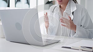 Asian female doctor using laptop computer online video call remote talking to patient, prescribe medicine