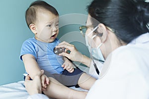 Asian female Doctor using stethoscope for checking heart beat with patient baby