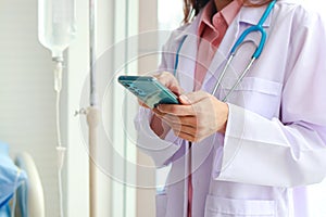 Asian female doctor working in office Holding a smartphone