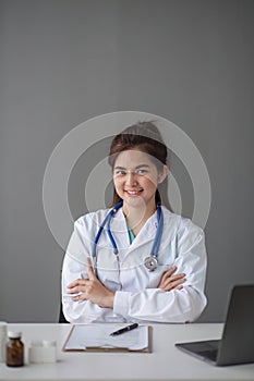 Asian female doctor working at a smiling desk in a hospital medical concept