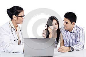 Asian female doctor with a young couple