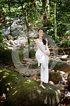 Asian female doing yoga in a park