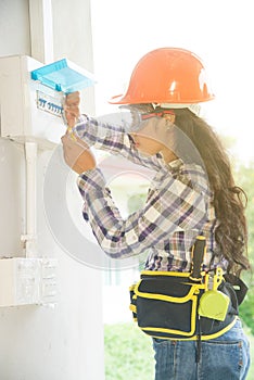 Asian female Electrician or Engineer check or Inspect Electrical system circuit Breaker.