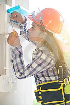 Asian female Electrician or Engineer check or Inspect Electrical system circuit Breaker.