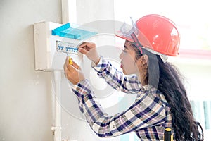 Asian female Electrician or Engineer check or Inspect Electrical system circuit Breaker.