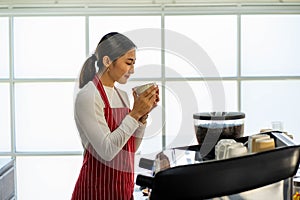 Asian female employee opening coffee shop cafe with bean grinder espresso machine. food and drink concpet