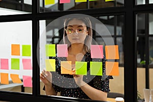 Asian female employee work on plan posting sticky notes