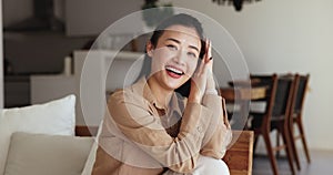 Asian female enjoy carefree relaxation seated on comfortable sofa